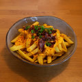Frieten met cheddarsaus, spek, bosui en chili zaden